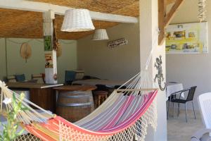 a hammock in a room with a bar at Domaine de Pouroutounat in Mirepoix