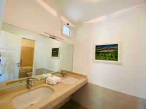 a bathroom with two sinks and a large mirror at La Villa nel Parco in Sanremo +5 photos