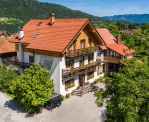 una vista aérea de una casa con techo rojo en Rooms Pevc & Hostel Ljubno ob Savinji en Ljubno