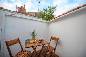 a table and two chairs on a balcony with a table and oranges at Ma Location Sablaise - Appart' Arago in Les Sables-d'Olonne