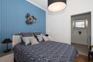 Schlafzimmer mit einem Bett mit blauer Wand in der Unterkunft L'épopée des coteaux 3☆ - centre ville - Epernay in Épernay