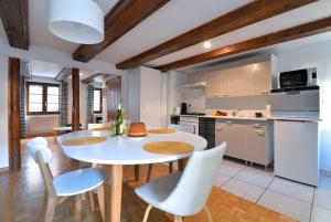 a kitchen and dining room with a white table and chairs at Appartement La Grande Terrasse du Centre in Colmar +11 photos