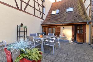 a patio with a table and chairs and a building at Appartement La Grande Terrasse du Centre in Colmar