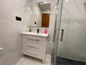 a white bathroom with a sink and a shower at Casa rural A Santiaga en Costa da Morte in Cabana de Bergantiños +17 photos