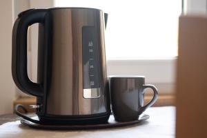 a coffee maker and a cup on a table at Rooms Pevc & Hostel Ljubno ob Savinji in Ljubno