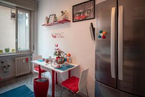 eine Küche mit einem Tisch und einem Kühlschrank in der Unterkunft Civico 8 B&B - Appartamento in Parma