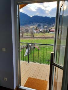 uma porta para uma varanda com vista para um campo em Oberland-Ferienwohnung em Unterammergau