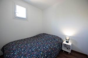 - une chambre avec un lit et une petite fenêtre dans l'établissement Ma Location Sablaise - Appart' Les Pins, à Les Sables-dʼOlonne