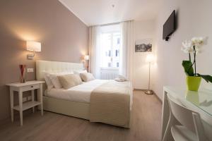 a white bedroom with a bed and a window at Le Stanze Di Gaia in Rome