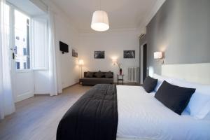 1 dormitorio con 1 cama blanca grande y 1 sofá en Le Stanze Di Gaia, en Roma