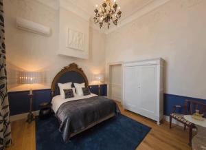 a bedroom with a bed and a chandelier at Louise sur Cour in Brussels