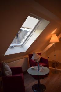 a attic room with a table and a window at Landgasthof Hüttenschenke in Kirchen