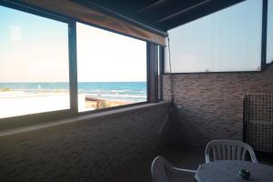 a room with a table and a view of the beach at Casa di lu mari in Tre Fontane