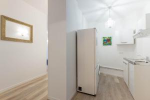 a white refrigerator in a kitchen with white walls at Marais Renard in Paris
