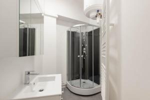 a white bathroom with a sink and a shower at Marais Renard in Paris