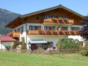 a large house with a balcony with flowers on it at Ferienhaus Alpenland in Flachau