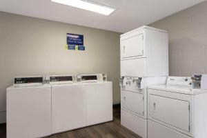 a laundry room with white washers and dryers at Days Inn by Wyndham Orlando Conv. Center/International Dr in Orlando