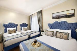 A bed or beds in a room at Ayasultan Hotel