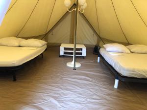 a tent with two beds and a pole in it at Camping Le Canoë in Chaussin