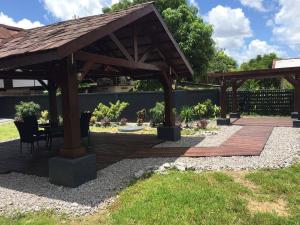 a wooden pergola with a table and chairs under it at Perfect stay apartments in Paramaribo