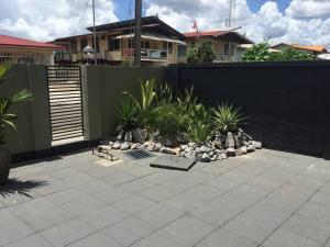 einen Hinterhof mit einem Zaun und einem Garten mit Pflanzen in der Unterkunft Perfect stay apartments in Paramaribo