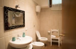 ein Badezimmer mit einem Waschbecken, einem WC und einem Spiegel in der Unterkunft Appartamento Belvedere in Monte Terminillo