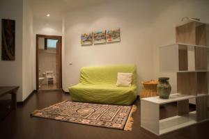 ein Wohnzimmer mit einem grünen Stuhl und einem Teppich in der Unterkunft Appartamento Belvedere in Monte Terminillo