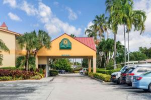 a hotel with cars parked in a parking lot at La Quinta by Wyndham Fort Lauderdale Pompano Beach in Fort Lauderdale