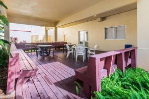 a wooden deck with a table and chairs on it at La Quinta by Wyndham Fort Lauderdale Pompano Beach in Fort Lauderdale