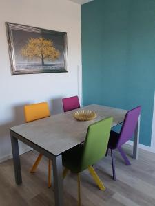 - une salle à manger avec une table et quatre chaises dans l'établissement L'épopée Panoramique - Parking - Avenue de Champagne - Epernay, à Épernay