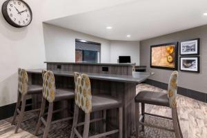 a bar in a hotel room with a clock on the wall at La Quinta by Wyndham Fairbanks Airport in Fairbanks