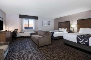 a hotel room with two beds and a couch at La Quinta by Wyndham Fairbanks Airport in Fairbanks