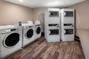 a laundry room with three washing machines and refrigerators at La Quinta by Wyndham Fairbanks Airport in Fairbanks