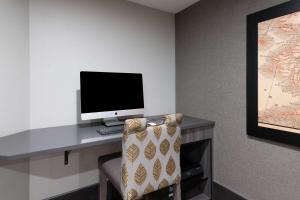 a computer monitor sitting on a desk with a chair at La Quinta by Wyndham Fairbanks Airport in Fairbanks