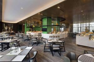 a restaurant with tables and chairs in a room at Wyndham JinJiang Hotel in Jinjiang