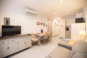 un soggiorno con un divano e un tavolo con una televisione di Résidence Bouttau by Connexion a Cannes