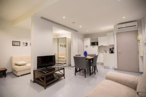 un soggiorno con un divano e un tavolo con una televisione di Résidence Bouttau by Connexion a Cannes