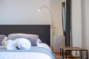 1 dormitorio con 1 cama con 2 almohadas blancas en Cap Away I Appart Hotel, en Andernos-les-Bains