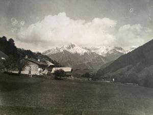 an old black and white photo of a house and mountains at Résidence la Chaumière in Les Gets