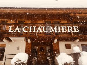 a sign on the side of a building in the snow at Résidence La Chaumière in Les Gets