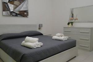 a bedroom with a bed with towels and a dresser at Your House in Olbia