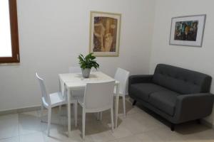 a living room with a table and a chair and a couch at Your House in Olbia +11 photos