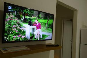 a television screen with a woman sitting on a table at Your House in Olbia