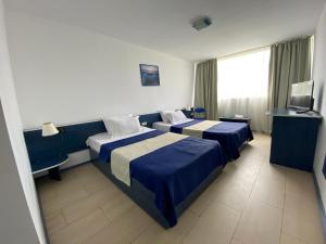 ヴィーナスにあるHotel Venusのベッド2台とテレビが備わるホテルルームです。