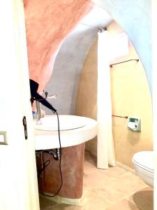 a bathroom with a sink and a toilet at Corte Del Campanaro in Ugento