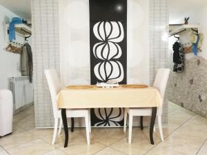 a dining room with a table and white chairs at Villa Carlini in Passoscuro