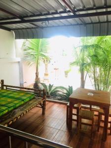 a room with a bench and a table and palm trees at thai-scout in Pran Buri