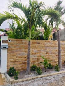 een houten hek met palmbomen erachter bij thai-scout in Pran Buri