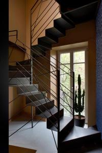 a black spiral staircase in a room with a cactus at VILLA ANNA Suite in Turin