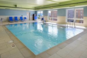 - une grande piscine dans un bâtiment avec des chaises bleues dans l'établissement Holiday Inn Express & Suites - Elko, an IHG Hotel, à Elko
